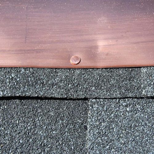 Black asphalt roofing shingles with copper flashing