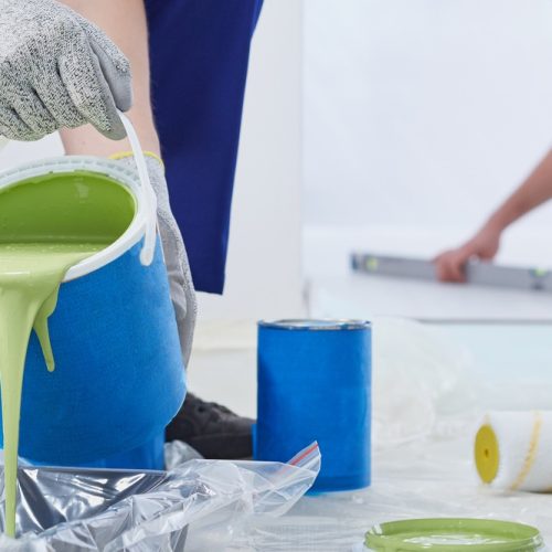 Builder pouring green wall paint