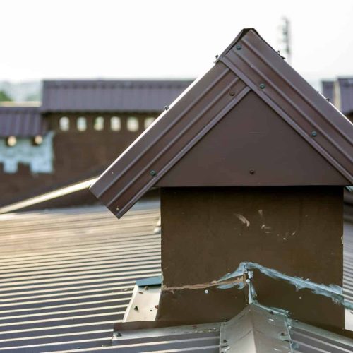 Close-up detail of new built brick plastered chimneys on house top