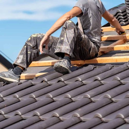 installation of roofing by a craftsman, ceramic tiles on wooden beams