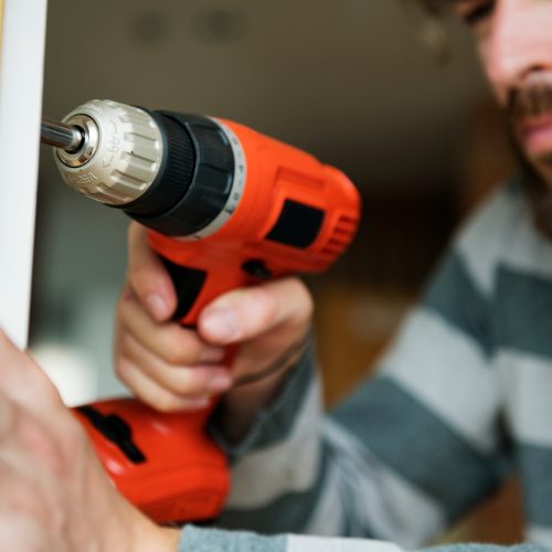 Man using electronic drill install door